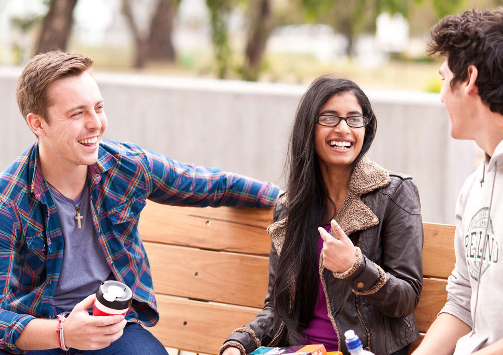 Students speaking on bench